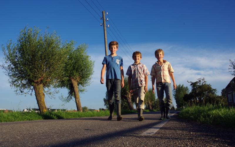 Drie jonge jongens wandelen over straat