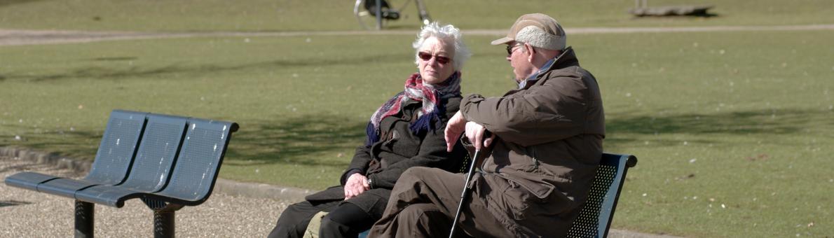 Senioren koppel op bank in park