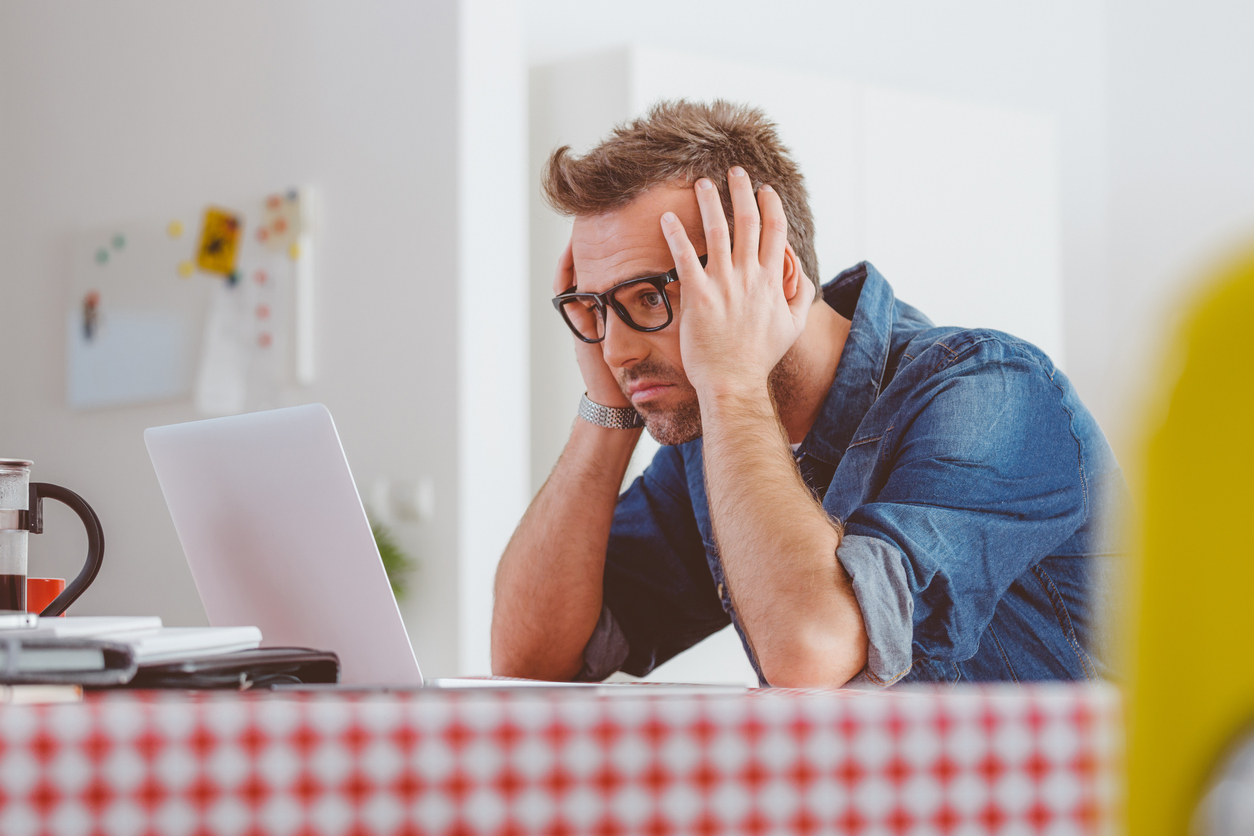 Bezorgde man kijkt naar laptop Bezorgde man kijkt naar laptop
