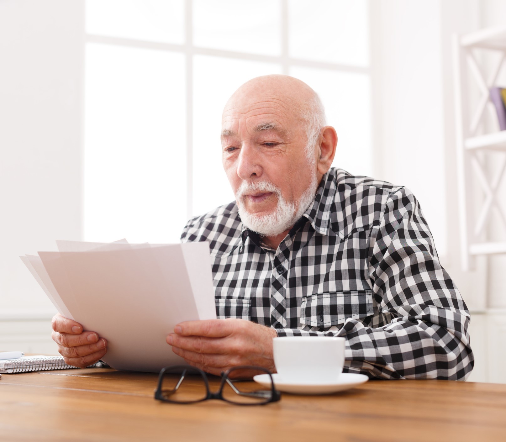 Man leest brieven aan keukentafel Man leest brieven aan keukentafel