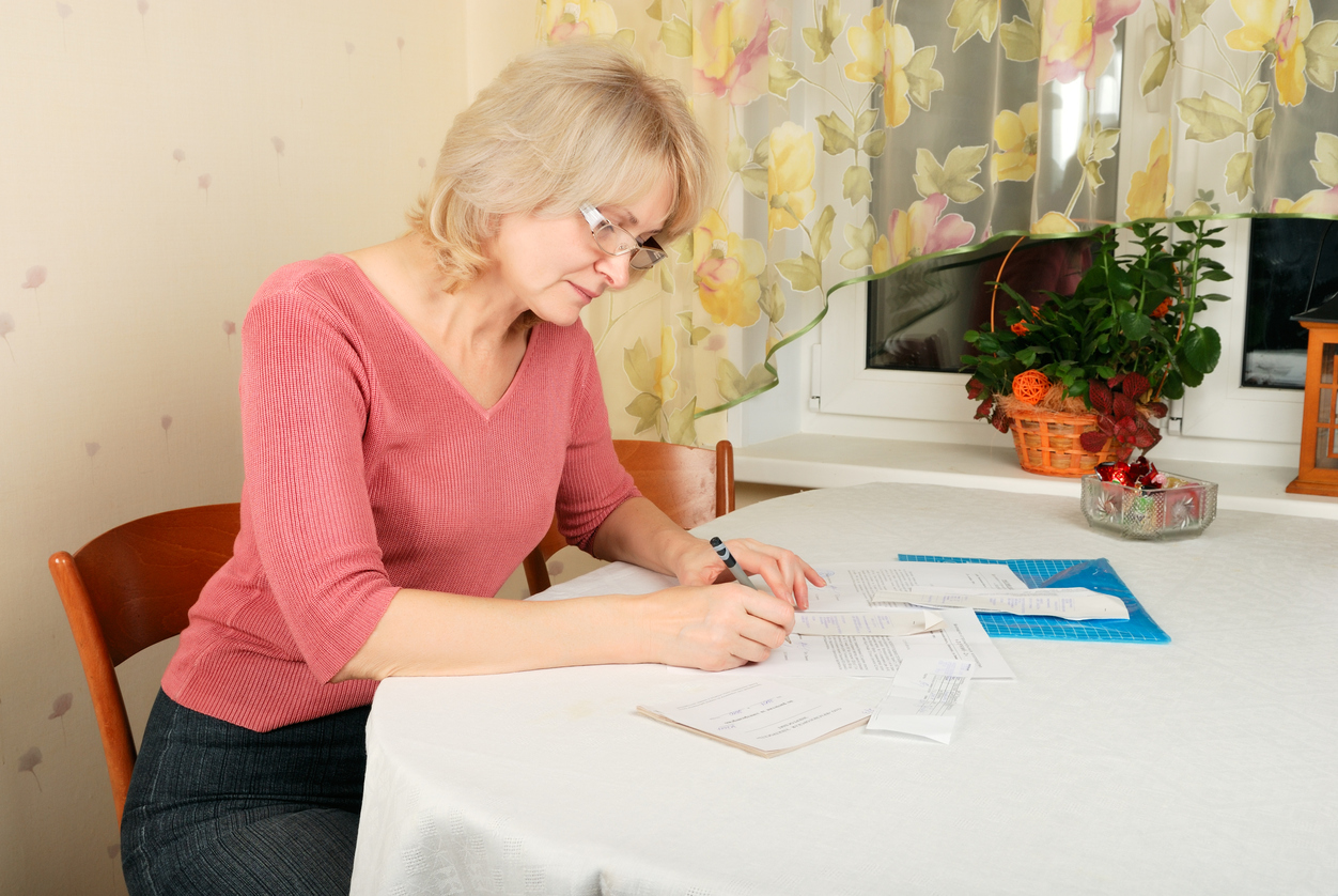 Vrouw met documenten aan tafel Vrouw met documenten aan tafel