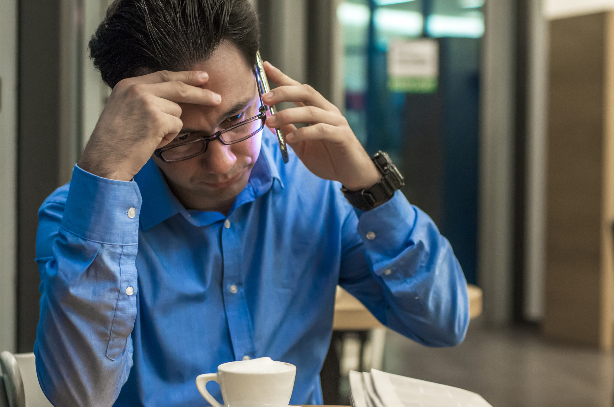 man aan de telefoon kijkt machteloos