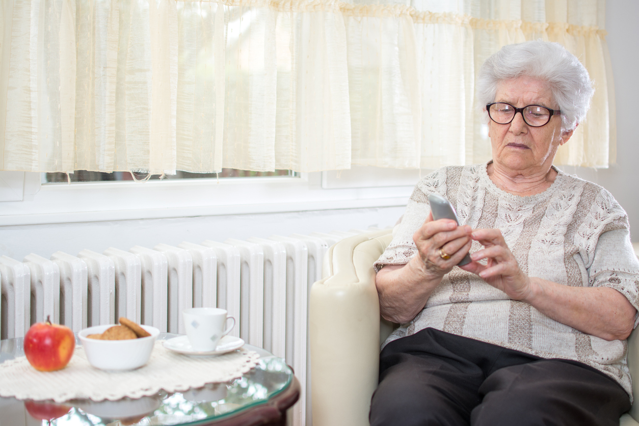 Bejaarde vrouw met telefoon in haar hand Bejaarde vrouw met telefoon in haar hand
