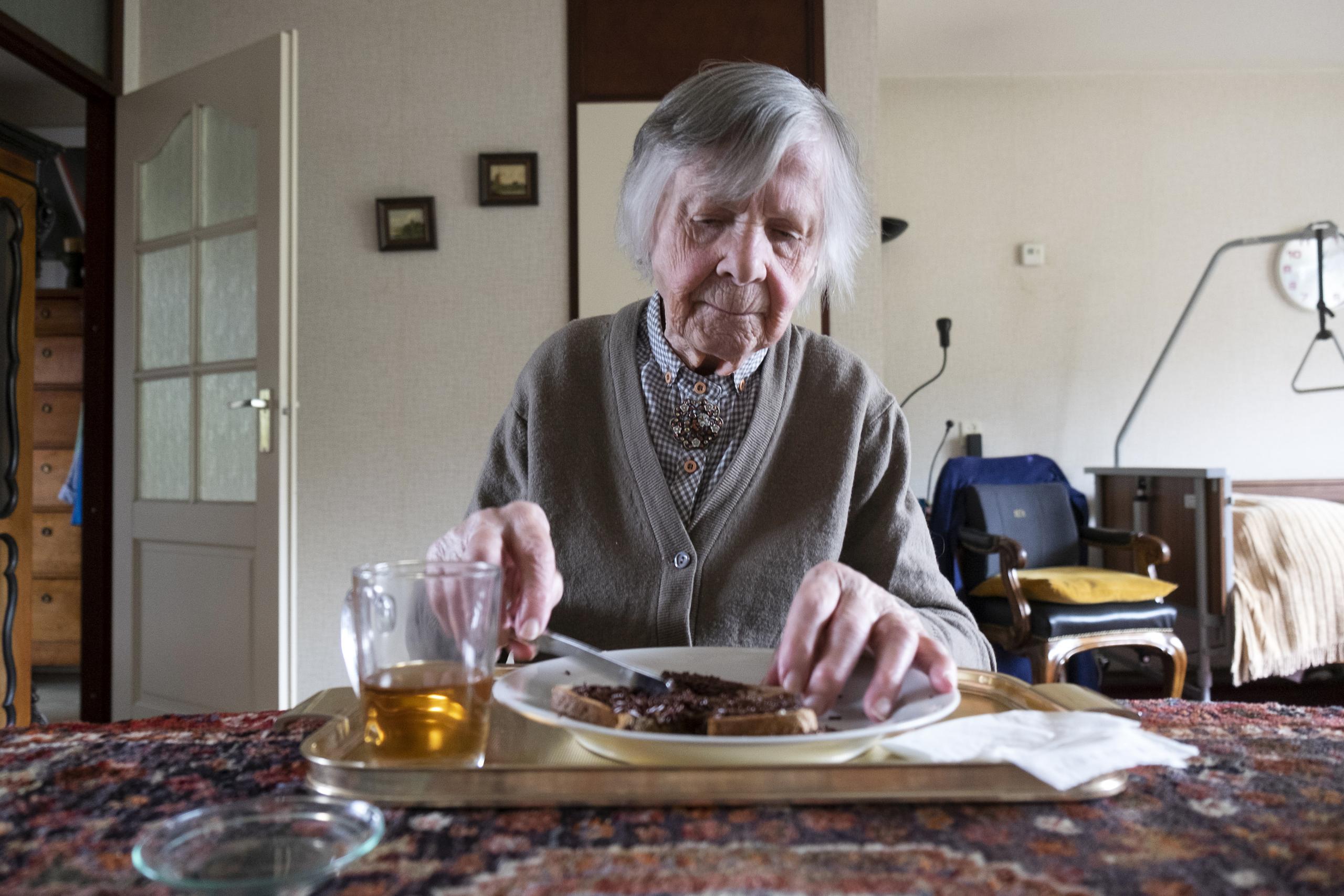 Dementerende vrouw eet een boterham Dementerende vrouw eet een boterham
