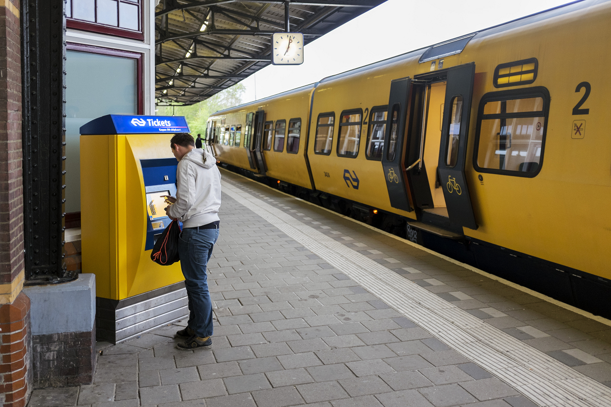 Man koopt treinkaartje op het station Man koopt treinkaartje op het station