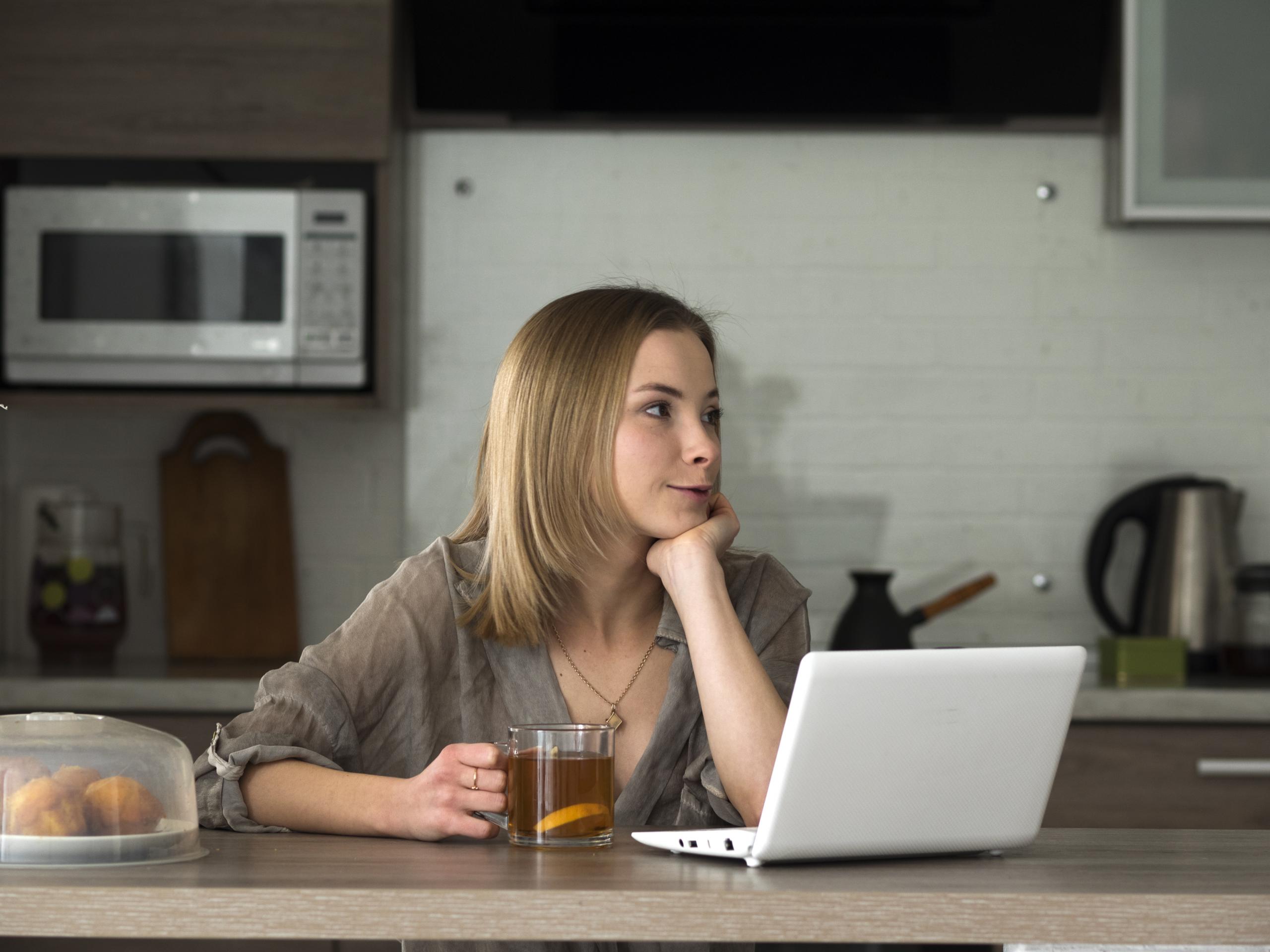 vrouw aan keukentafel met laptop vrouw aan keukentafel met laptop