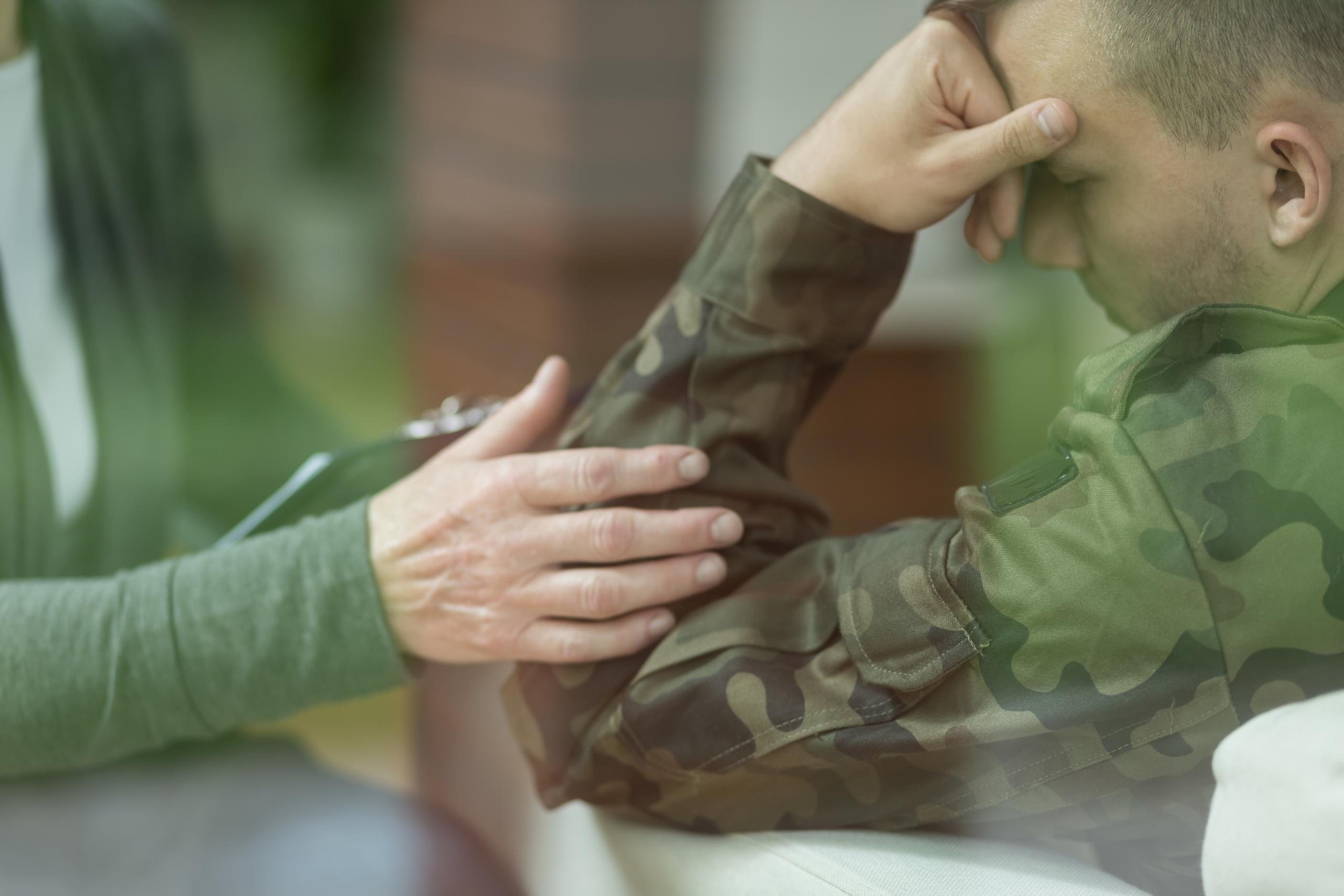 Foto van een veteraan en iemand die hem troost Foto van een veteraan en iemand die hem troost