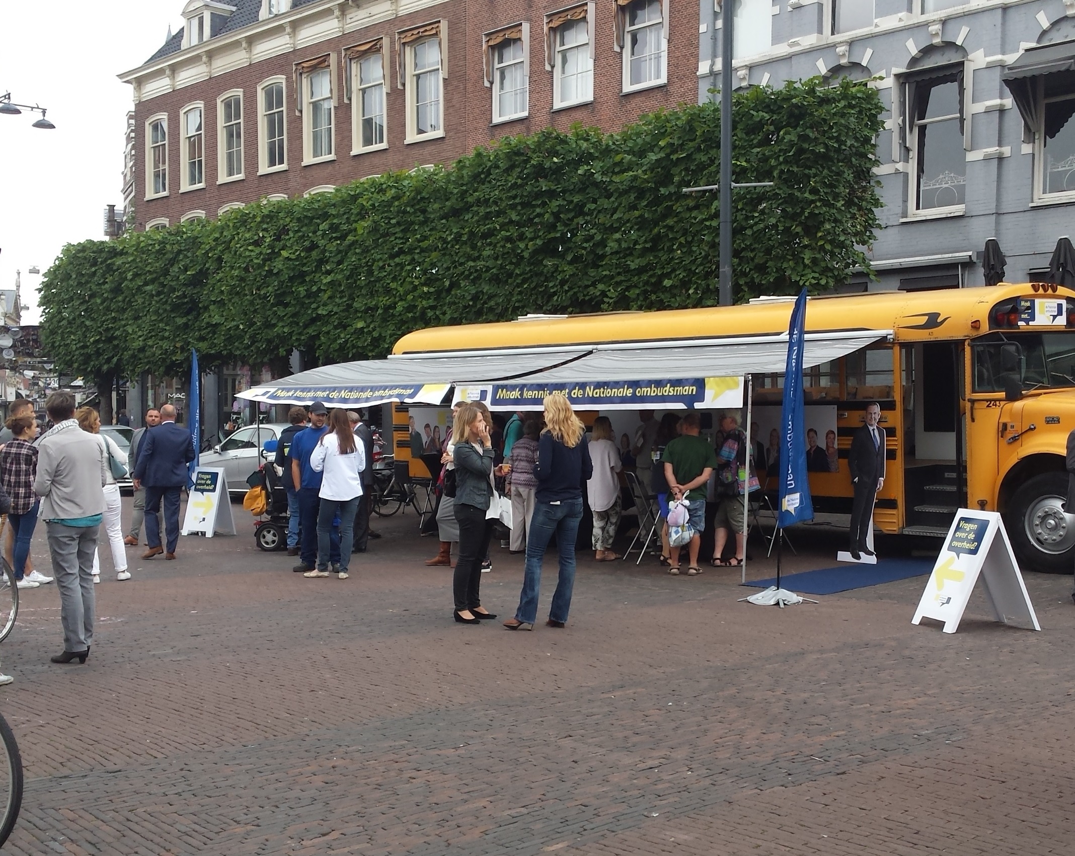 Foto van de gele Ombudsbus op de markt
