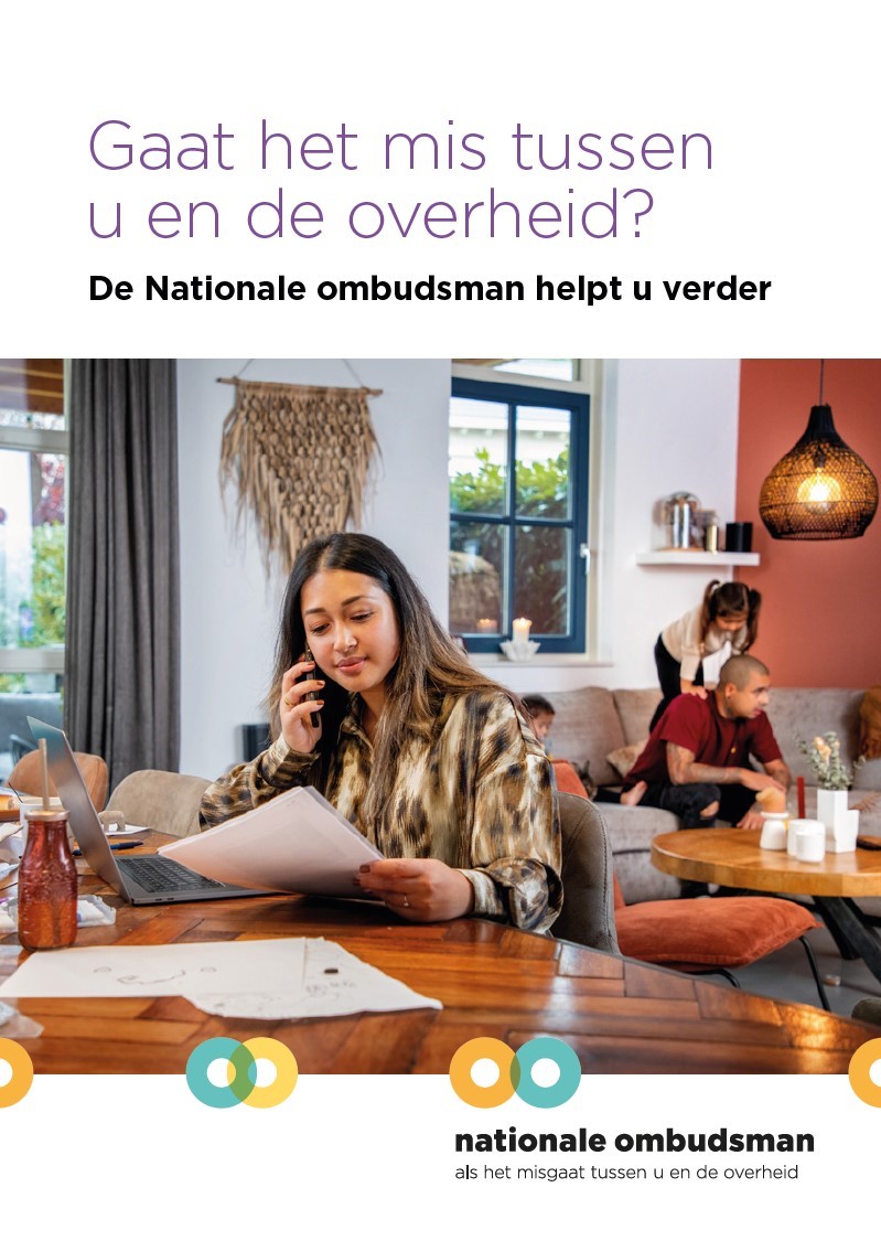 Vrouw zit aan tafel met telefoon en regelt zaken