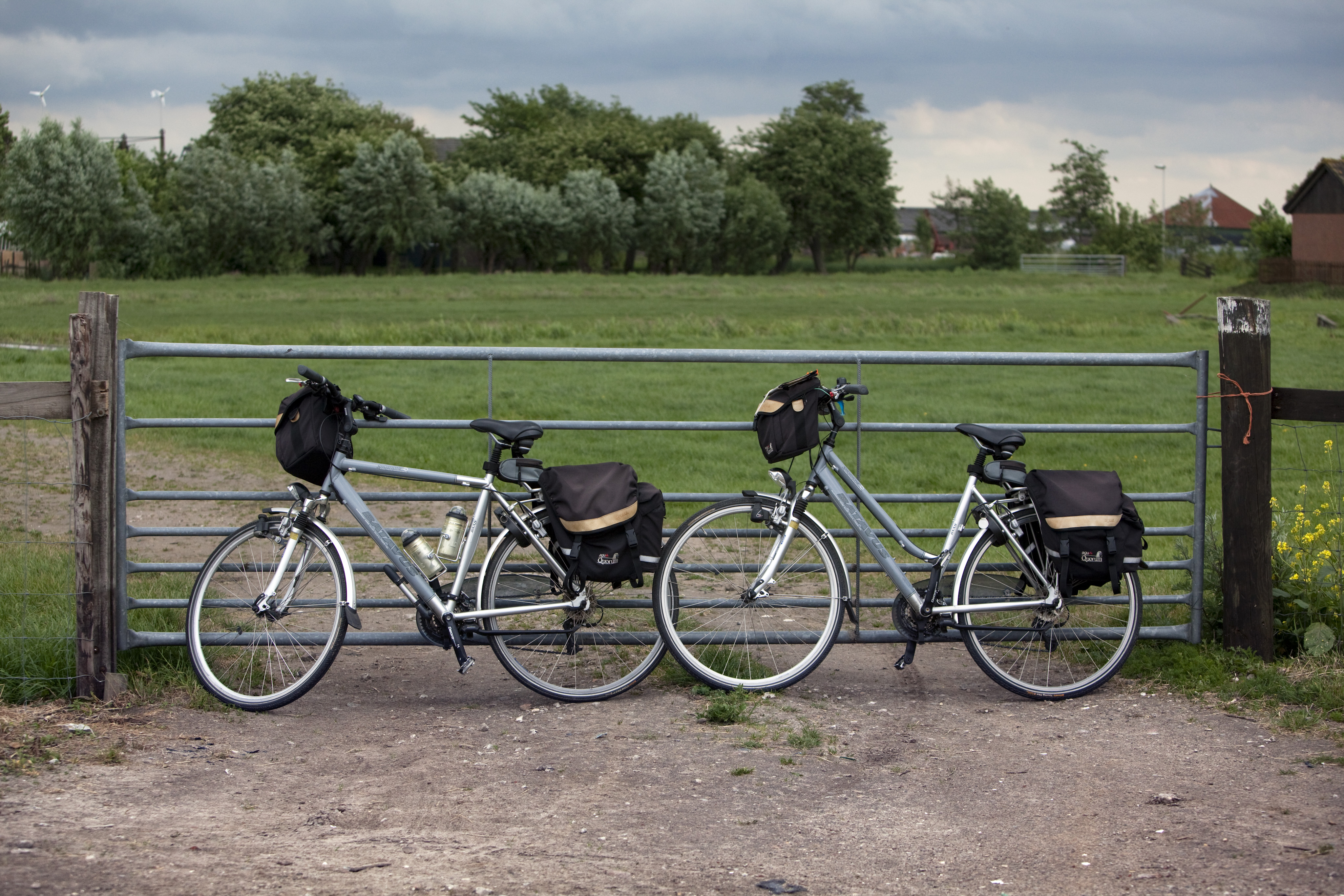 Foto van twee fietsen tegen een hek voor een weiland Foto van twee fietsen tegen een hek voor een weiland