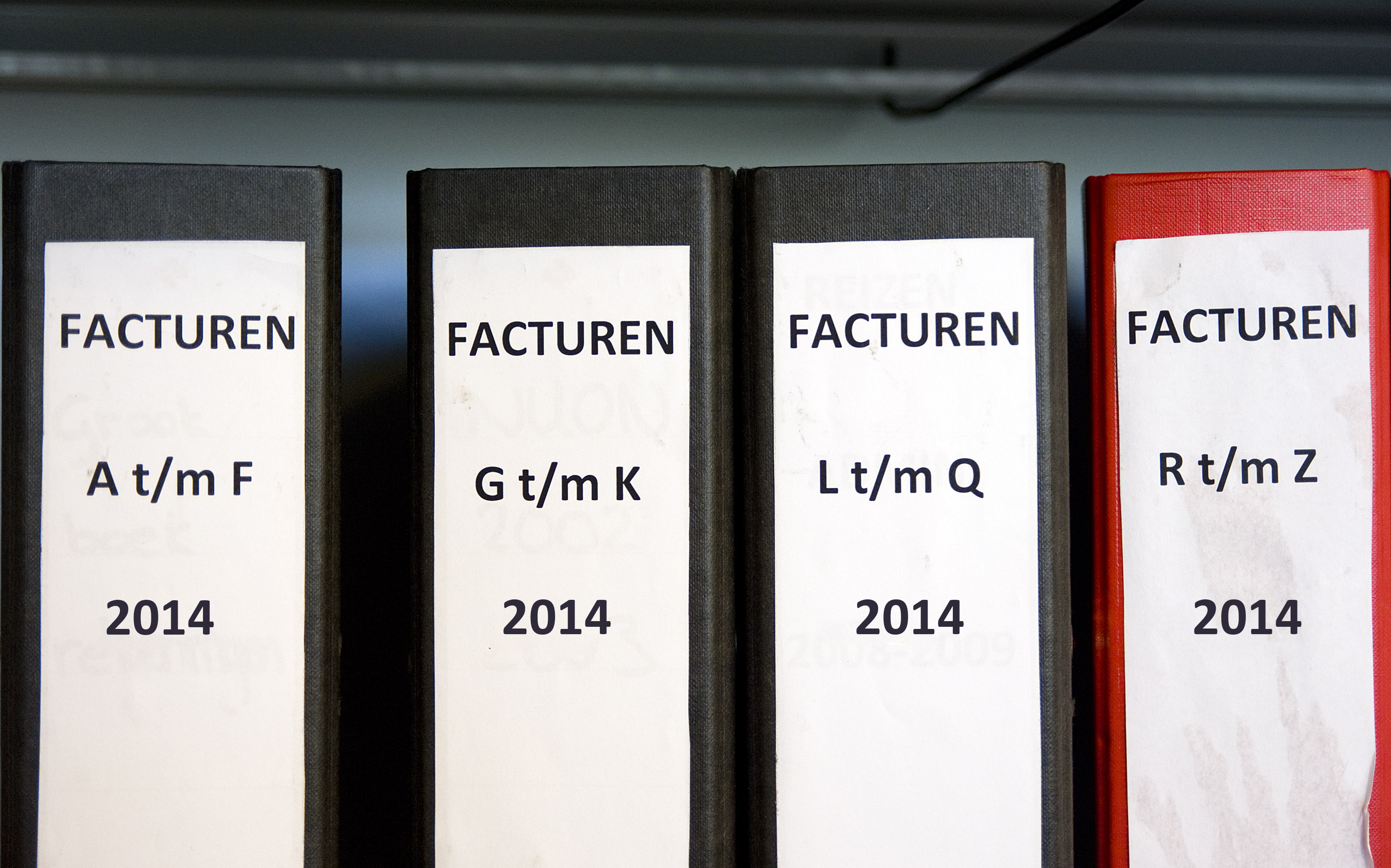 Foto van ordners met facturen Foto van mappen met jaartallen erop