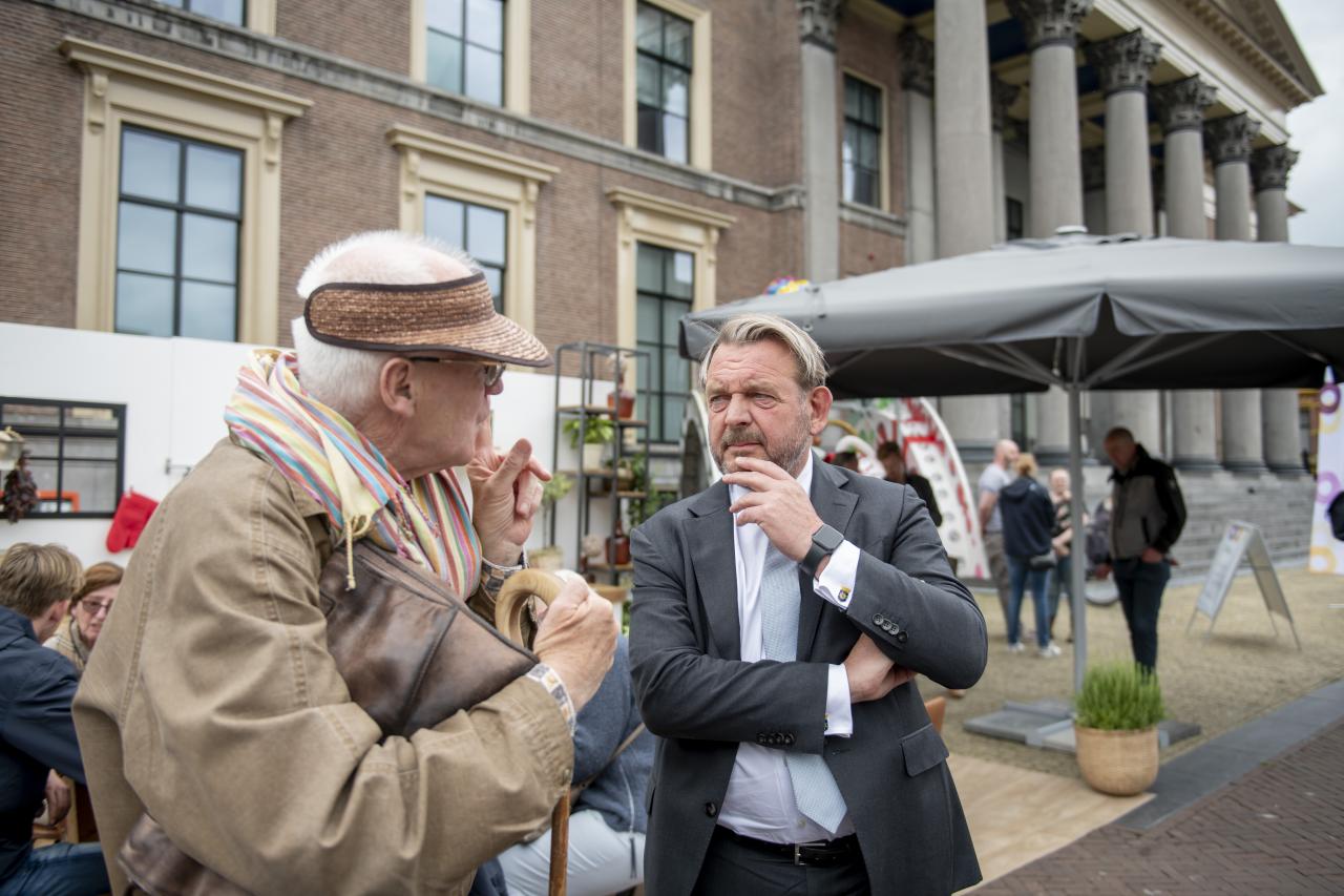 Reinier van Zutphen, Nationale ombudsman, in gesprek met een oudere man op straat.