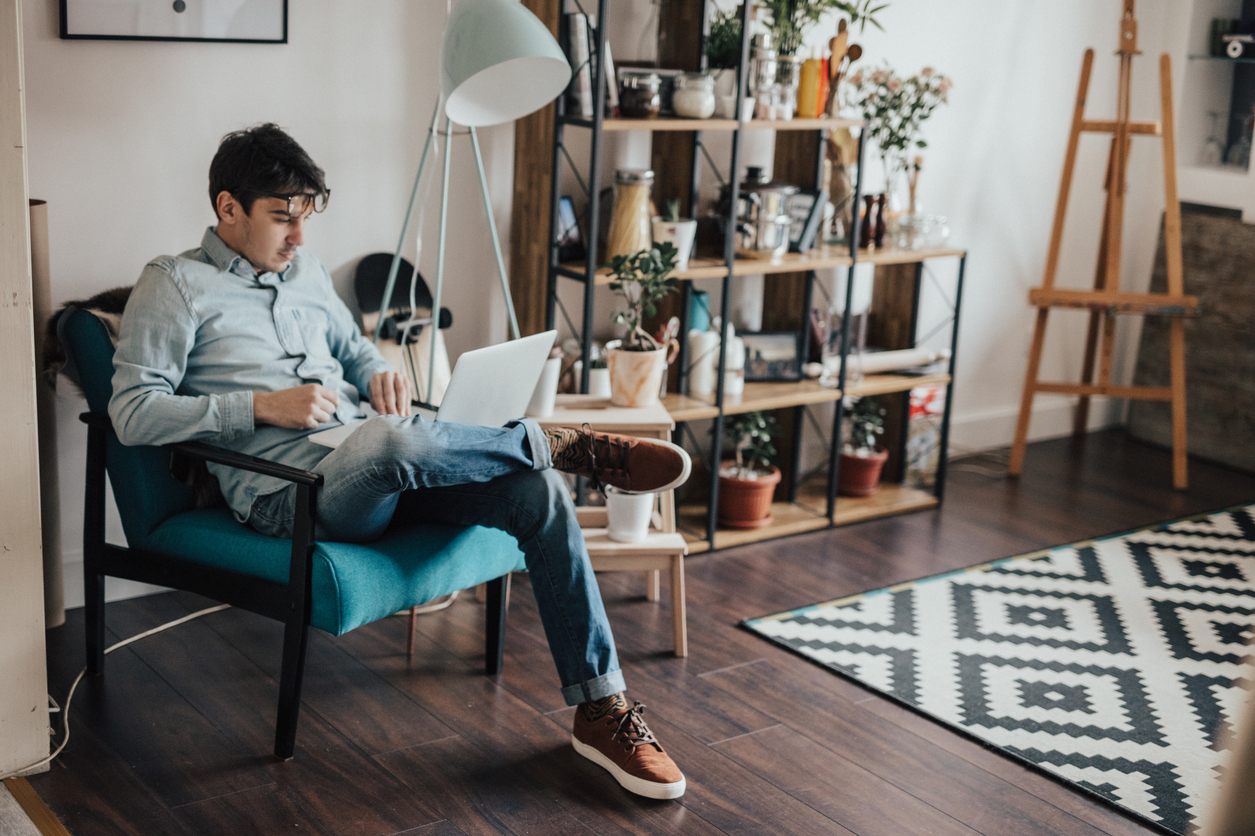 Jongen in huiskamer achter laptop