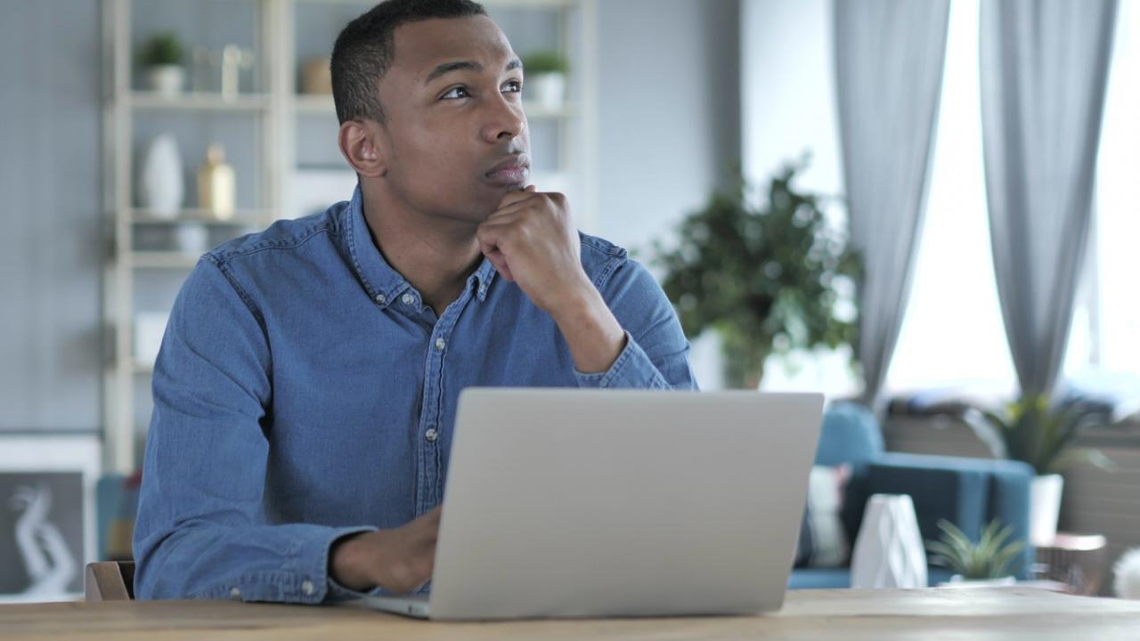 Man nadenkend achter laptop