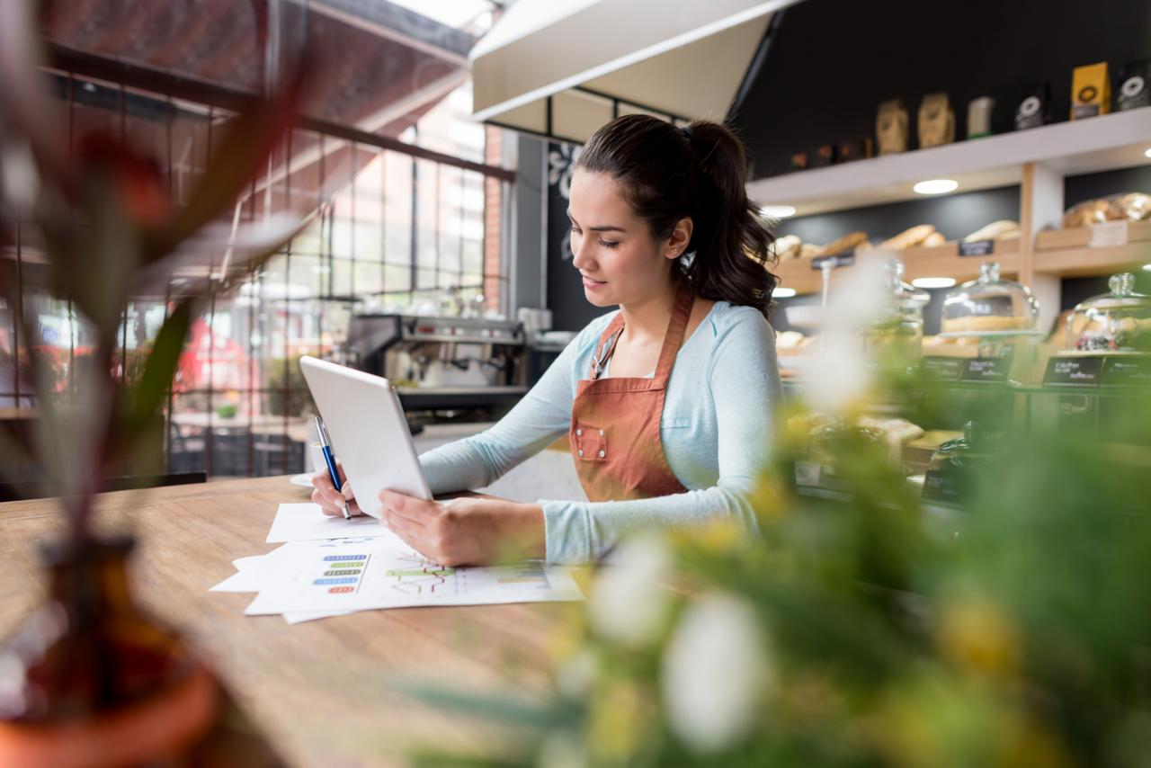 Vrouw zit achter laptop aan tafel