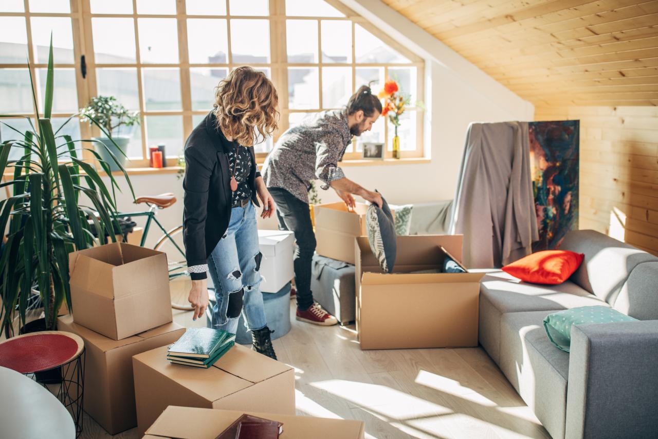 Stel verhuist naar nieuw appartement, staat tussen de verhuisdozen