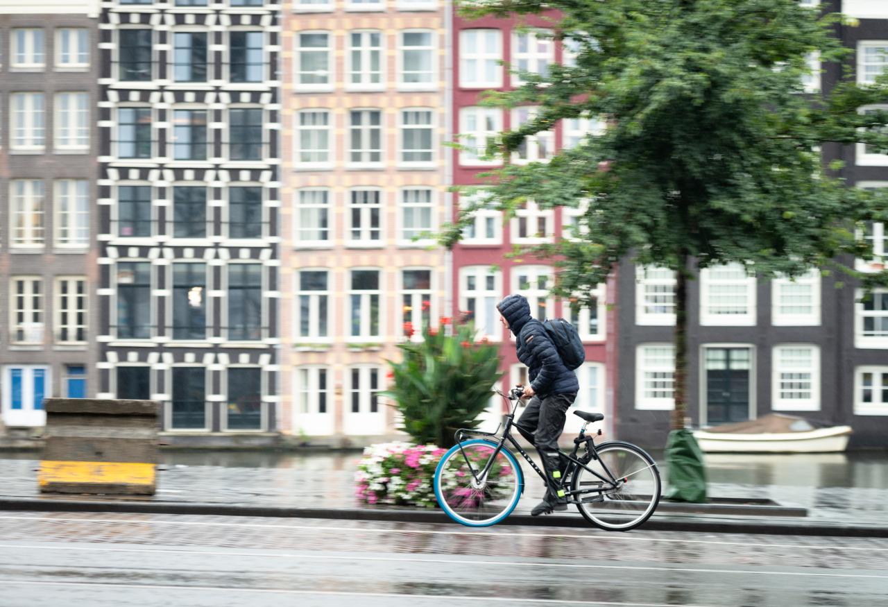Jongen fietst in de regen en storm