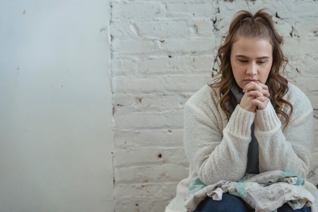 Jonge vrouw zit met gekruiste handen (Sara 2)