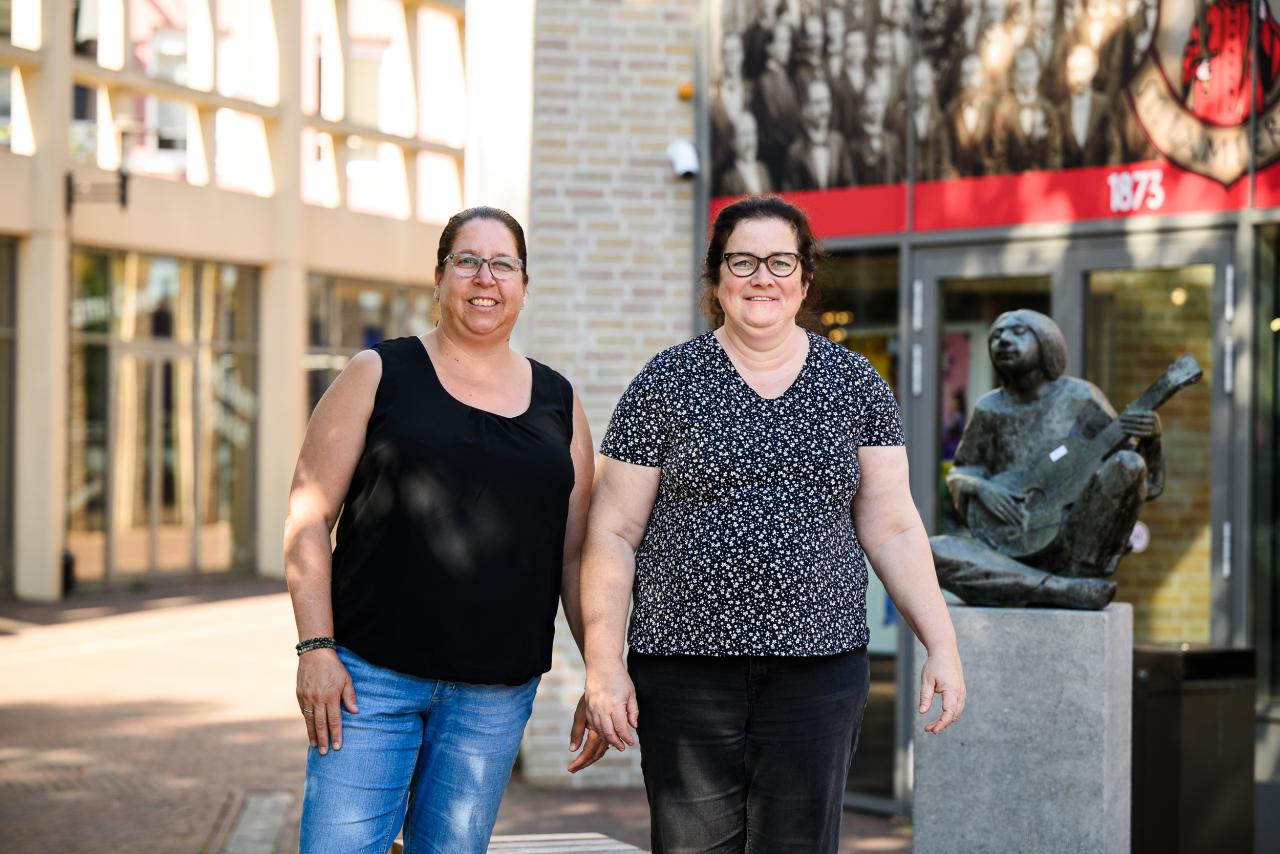 Twee vrouwen staan voor de bibliotheek. 