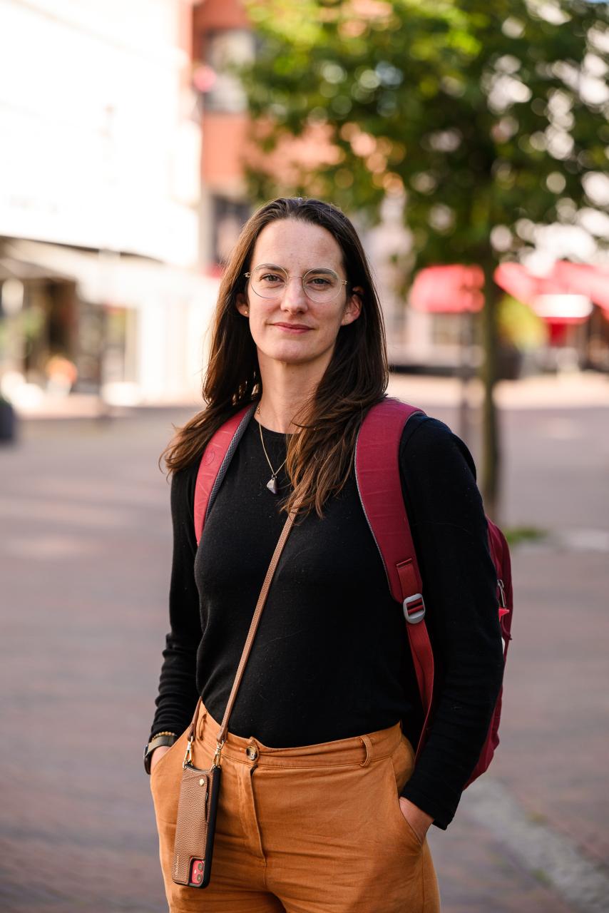 Een vrouw met haar handen in haar broek staat in het centrum van Kerkrade