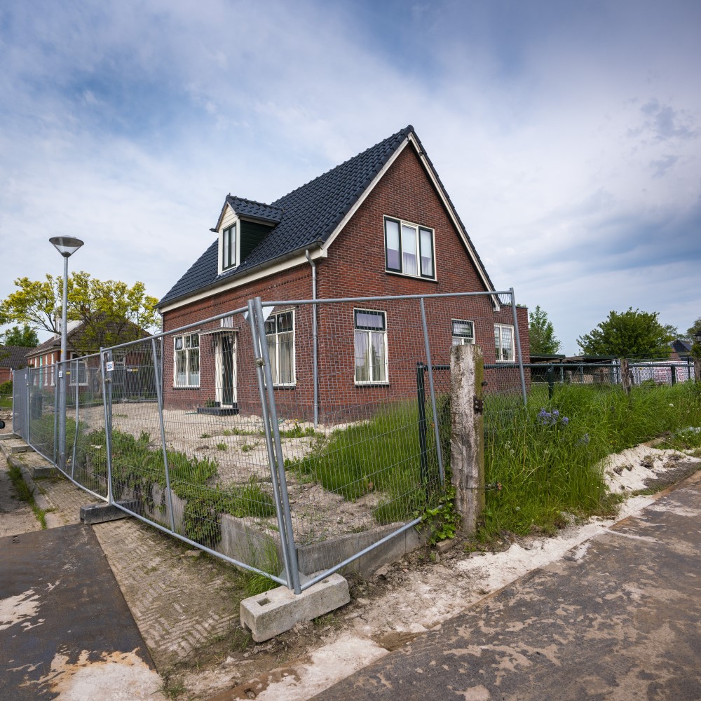 Een huis in Groningen tussen de bouwhekken.