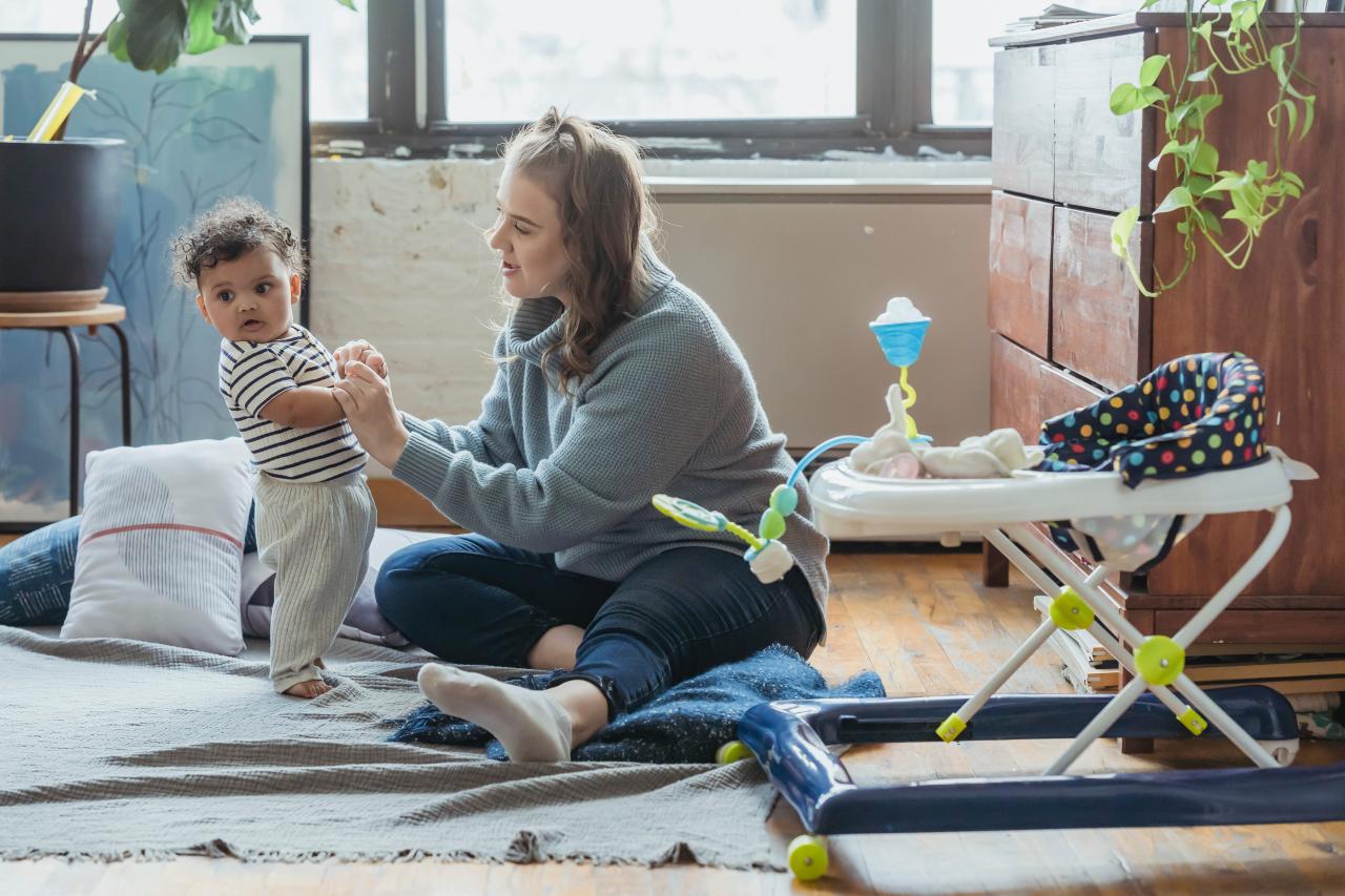 Jonge moeder speelt in huiskamer met baby