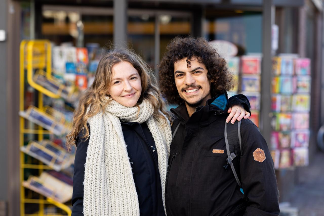 Jonge blonde vrouw en jonge man met donker krullend haar.