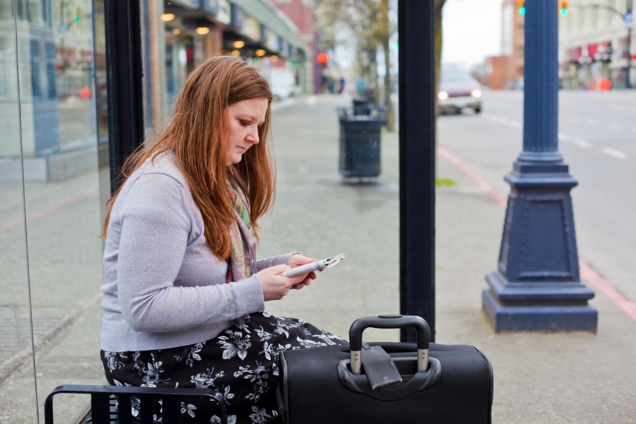 Vrouw met koffer bij de bushalte