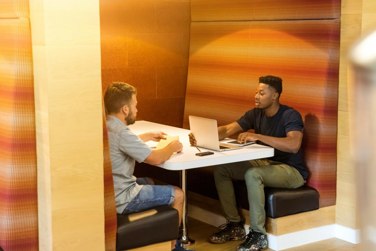 Twee jonge mannen met elkaar in gesprek.