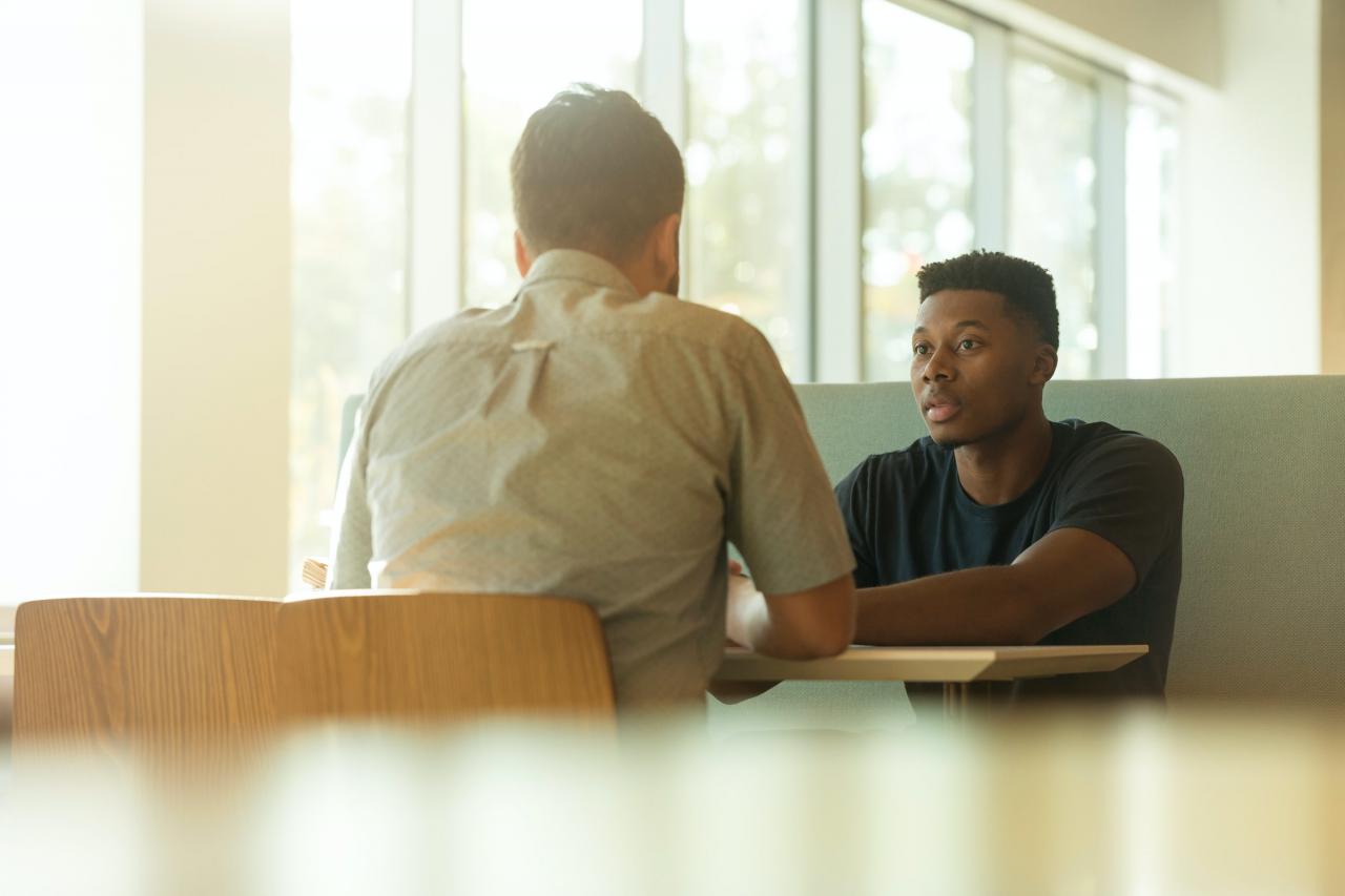 Twee jongen mannen met elkaar in gesprek