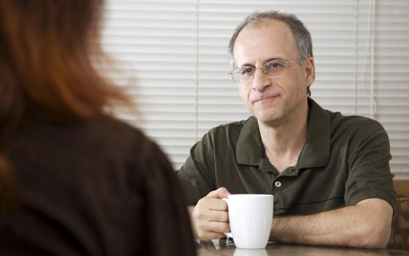 Foto van twee mensen in gesprek aan een tafel