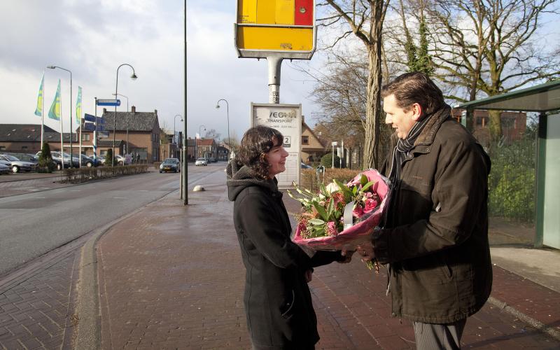 Foto van een man die op straat een bos bloemen geeft aan een vrouw Foto van een man die op straat een bos bloemen geeft aan een vrouw