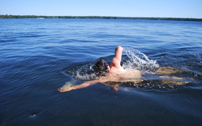 Foto van een man die in een meer zwemt
