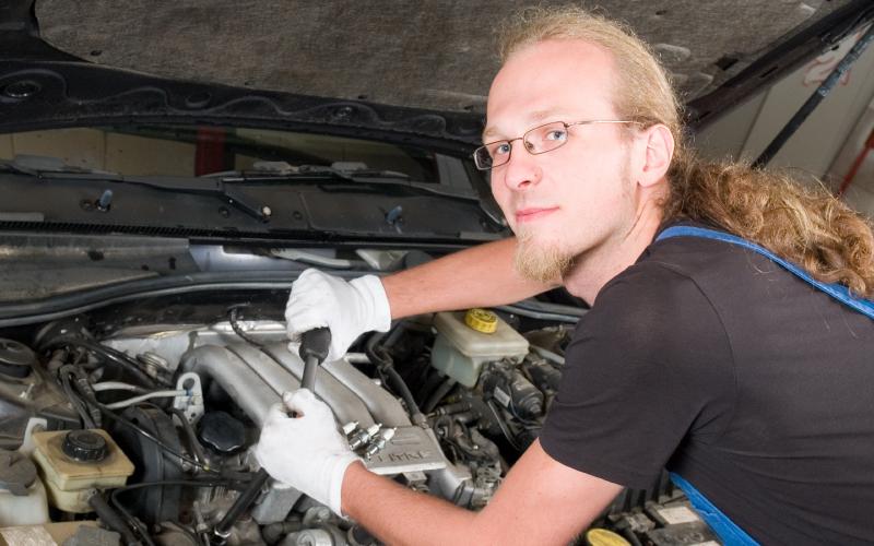 Man sleutelt aan auto Man sleutelt aan auto