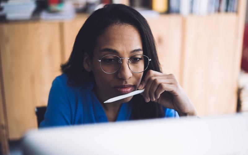 Vrouw met bril en tablet pencil in haar hand kijk op haar tablet of computerscherm. Ze is aan het werk. Vrouw met bril en tablet pencil in haar hand kijk op haar tablet of computerscherm. Ze is aan het werk.