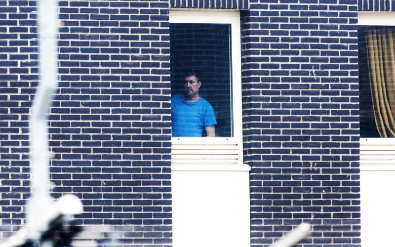 Man in detentie. Hij draagt een blauw shirt