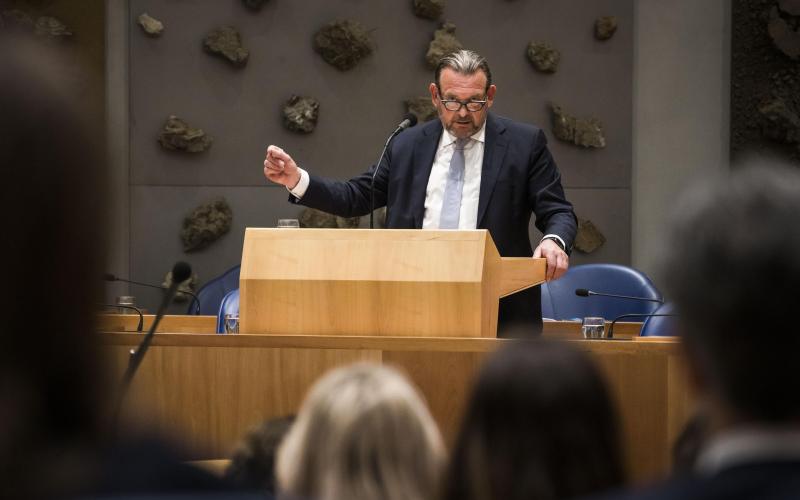 De Nationale ombudsman in de Tweede Kamer. Hij staat en spreekt in een microfoon over het Jaarverslag 2022.