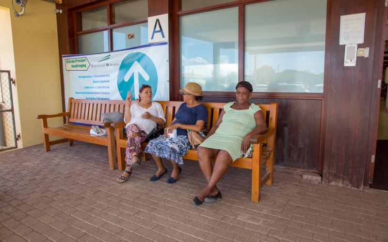 Drie oudere vrouwen wachten op een bank