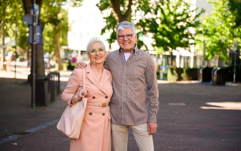 Een ouder stel staat in een winkelstraat Een ouder stel staat in een winkelstraat
