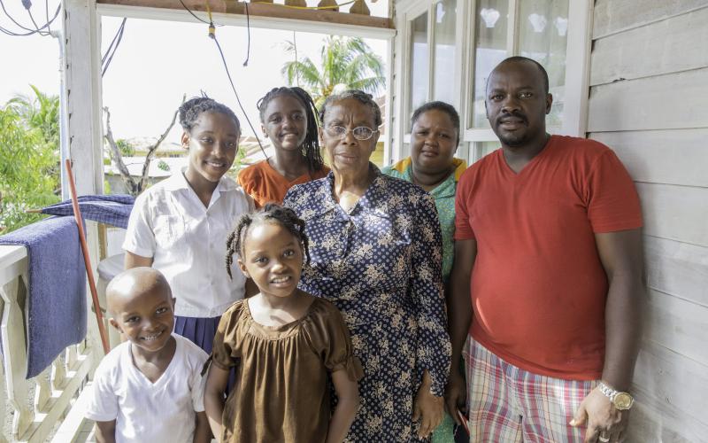 Multiple generations of people are standing together for a group picture