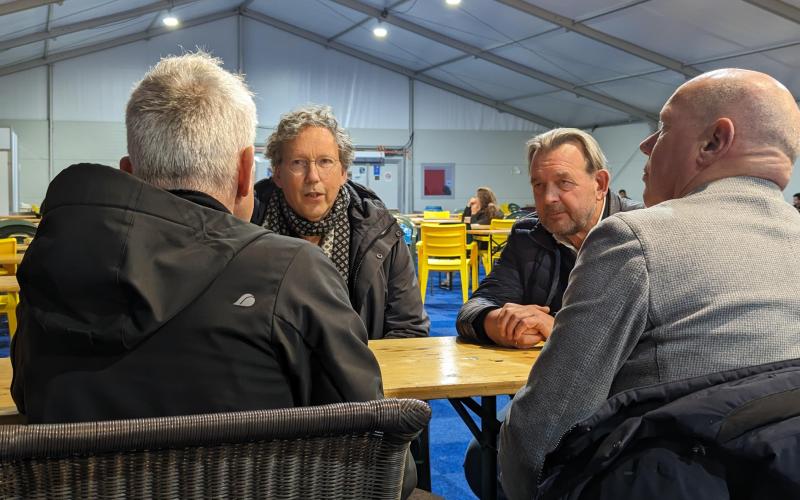 Voorzitter Vluchtelingenwerk Frank Candel en Nationale ombudsman Reinier van Zutphen in gesprek met twee medewerkers van het COA