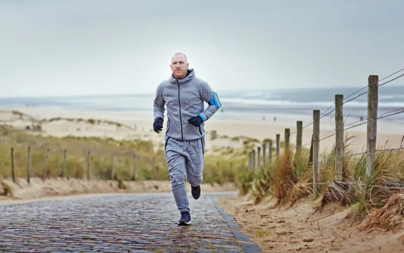 Man aan het joggen op de duinen bij het strand