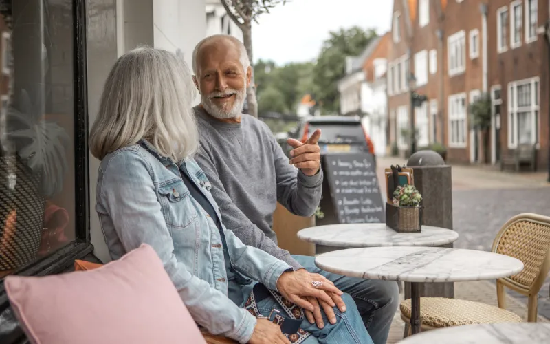 Senior gepensioneerde man zit met vrouw op het terras