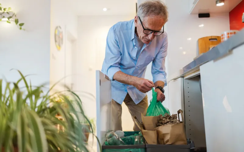 Oudere man gooit afval weg