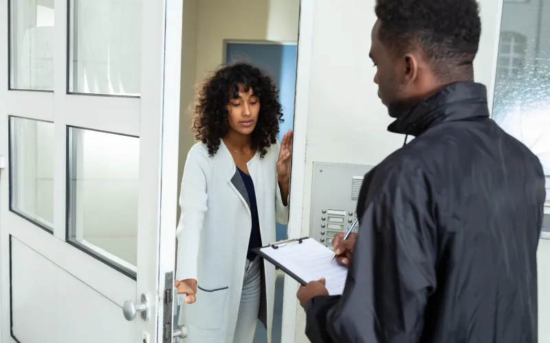 Vrouw aan de deur met deurwaarder