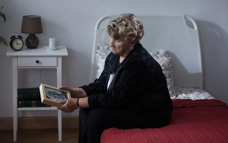Vrouw met portret van overleden man in haar hand