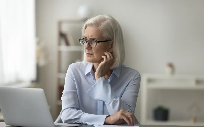 Vrouw achter laptop met een bezorgde blik