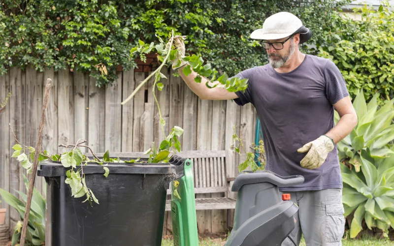 man haalt onkruid uit tuin