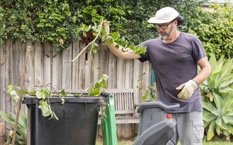 man haalt onkruid uit tuin