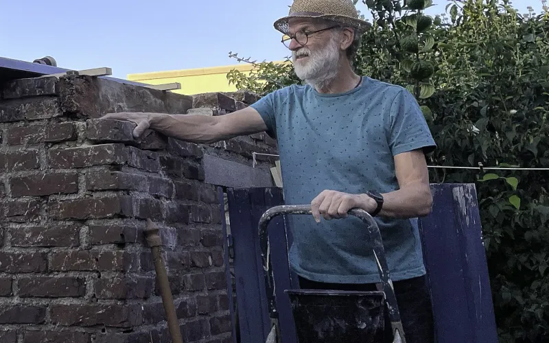 Man bij huismuur